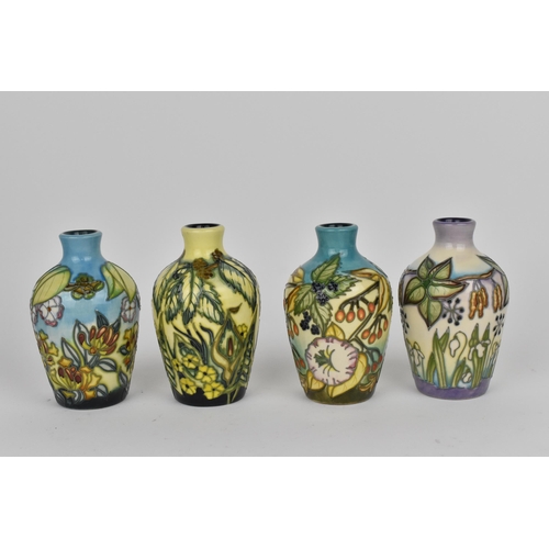 83 - A cased set of Moorcroft pottery small posy vases, in various floral patterns, dated 2000, possibly ... 