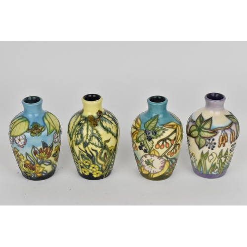 83 - A cased set of Moorcroft pottery small posy vases, in various floral patterns, dated 2000, possibly ... 