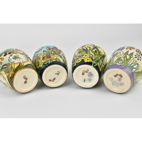 83 - A cased set of Moorcroft pottery small posy vases, in various floral patterns, dated 2000, possibly ... 