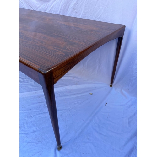 97 - A Heals rosewood dining table, of rectangular form with tapered legs ending in brass disc feet, toge... 