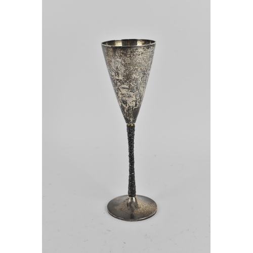 111 - A 1970s silver champagne flute by Stuart Devlin, the conical bowl above a textured stem with spreadi... 