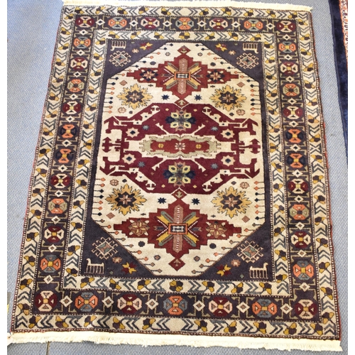 246 - A Kazak rug with three medallions on an off white ground in red, blue, yellow, orange and brown, 153... 