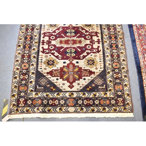 246 - A Kazak rug with three medallions on an off white ground in red, blue, yellow, orange and brown, 153... 