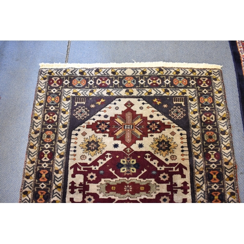 246 - A Kazak rug with three medallions on an off white ground in red, blue, yellow, orange and brown, 153... 