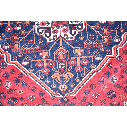 154 - A Kashgai carpet with a central medallion, geometric animals, birds and flowers on a red ground, 275... 