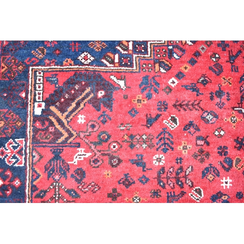 154 - A Kashgai carpet with a central medallion, geometric animals, birds and flowers on a red ground, 275... 