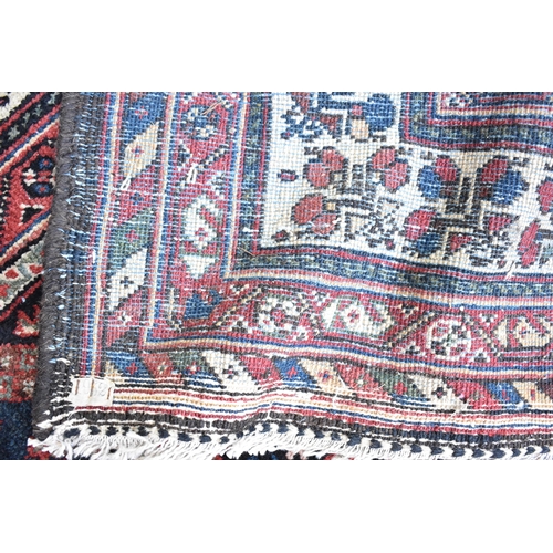 162 - A Bokhara rug with twin diamond medallions and repeated flowers on a dark blue ground, 171cm x 282cm