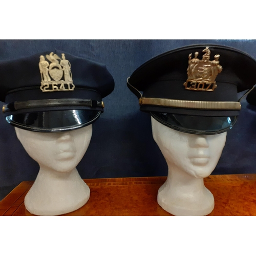 67 - Four Worldwide police hats comprising an NYPD police officer's cap made by Tanen Uniform Cap Co, NY,... 