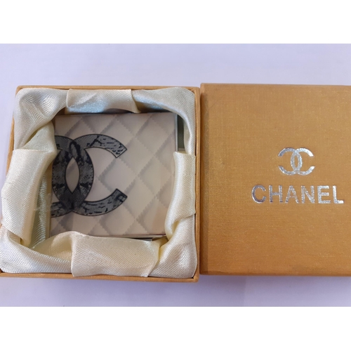 81 - A vintage Chanel double mirror compact with iconic double CC logo on a white tone background, with b... 