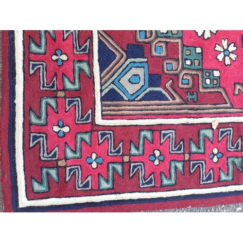 82 - A Debenhams crewel work wall tapestry with tab heading depicting crosses amongst the border in reds,... 