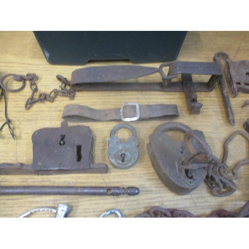 368 - A box of various Indian locks and other locks, a man trap, handcuffs and other items together with a... 