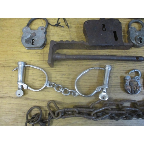 368 - A box of various Indian locks and other locks, a man trap, handcuffs and other items together with a... 