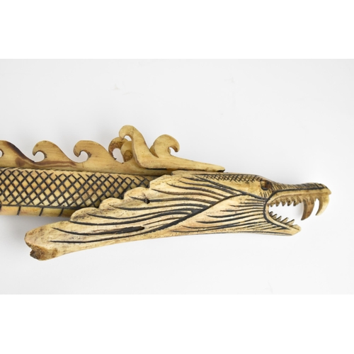 370 - A carved bone tribal blowpipe with dragon design, 125 cm long, together with a bamboo and wood blowp... 