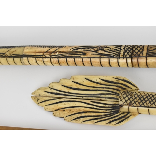 370 - A carved bone tribal blowpipe with dragon design, 125 cm long, together with a bamboo and wood blowp... 