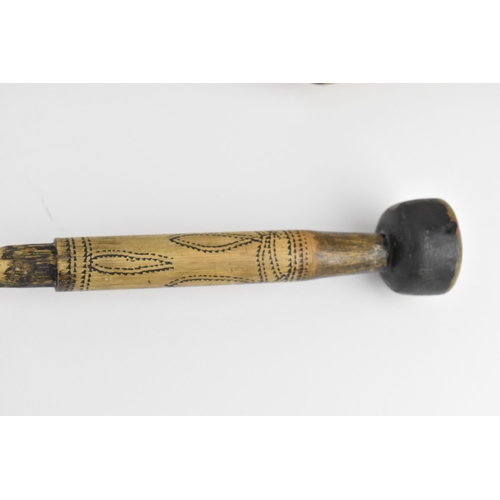 370 - A carved bone tribal blowpipe with dragon design, 125 cm long, together with a bamboo and wood blowp... 