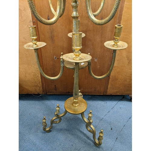 378 - A Middle Eastern brass nine branch candelabrum having engraved decoration and scroll shaped feet, 12... 