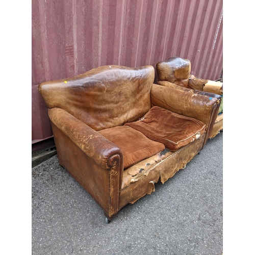 392 - A late 19th/early 20th century brown leather upholstered two seater sofa and matching armchair A/F
L... 