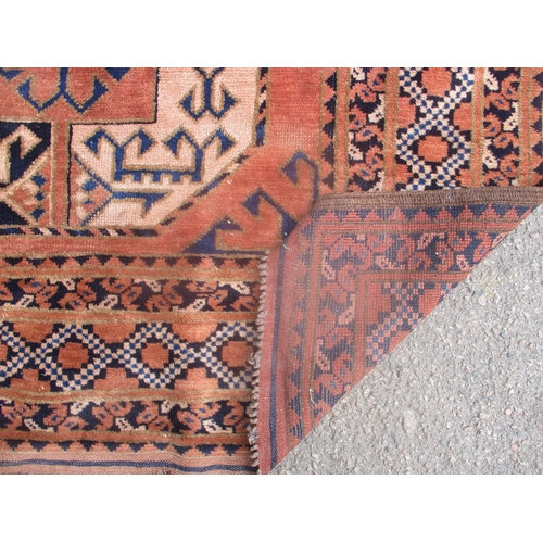 407 - An early 20th century hand woven small Middle Eastern rug, two central octagonal medallions with geo... 