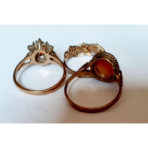 192 - A 9ct gold dress ring with central orange cabochon surrounded by square cut and circular white stone... 