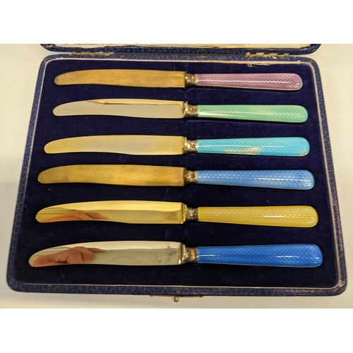 204 - A cased set of six silver rimmed butter knifes with enamelled handles and gilded blades
Location: BR