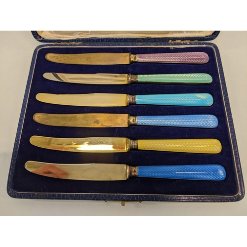 204 - A cased set of six silver rimmed butter knifes with enamelled handles and gilded blades
Location: BR