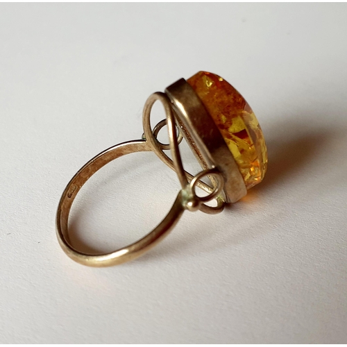 11 - A silver gilt and and amber dress ring having a raised mount, total weight 3.8g, UK ring size O. Loc... 