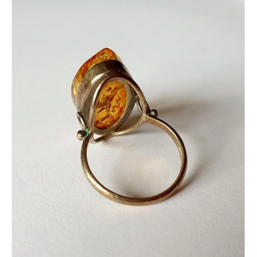 11 - A silver gilt and and amber dress ring having a raised mount, total weight 3.8g, UK ring size O. Loc... 