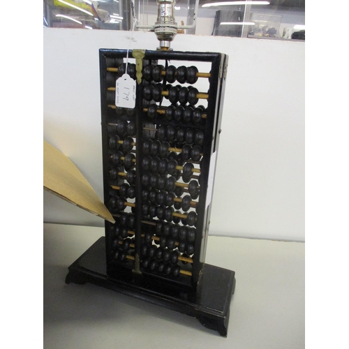 179 - A table lamp converted from two Chinese wooden abacus and mounted on an ebonized base, along with a ... 