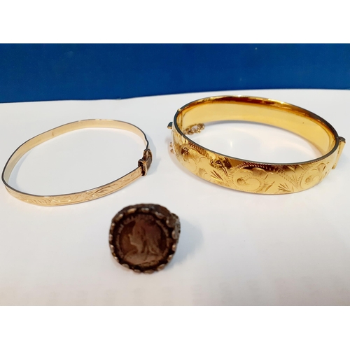 36 - A quantity of costume jewellery to include an engraved gold plated bangle with safety chain and anot... 