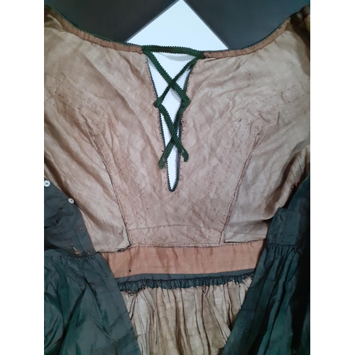 43 - A Victorian ladies hand-made silk dress in dark green having 3 horizontal black lace panels to the c... 