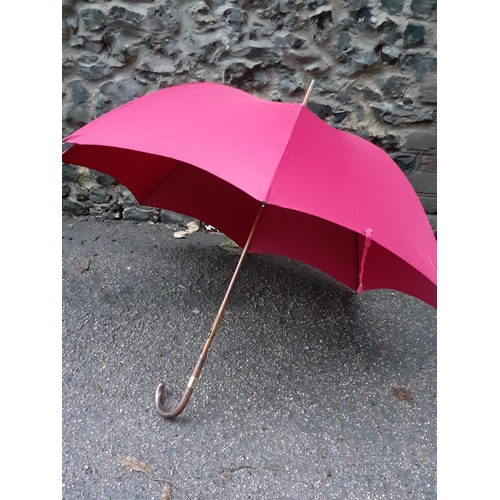 60 - An Edwardian Briggs burgundy umbrella, circa 1911, refurbished by Briggs in 2022, having a leather h... 