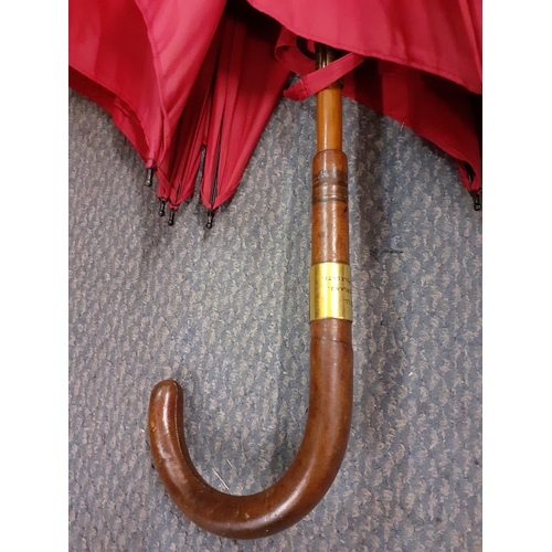 60 - An Edwardian Briggs burgundy umbrella, circa 1911, refurbished by Briggs in 2022, having a leather h... 