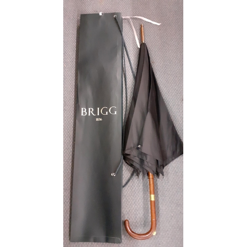 61 - A Vintage Briggs black umbrella, with incorporated racing pencil, engraved gold plated band, leather... 