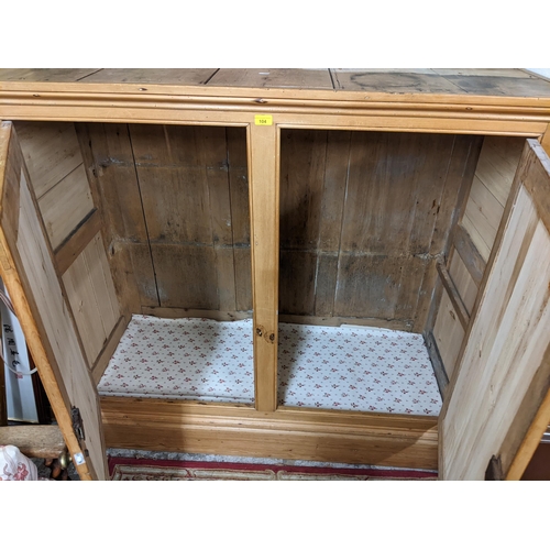 104 - A large Victorian pine two door cabinet having metal turned handles and on a plinth base, 127h x 140... 