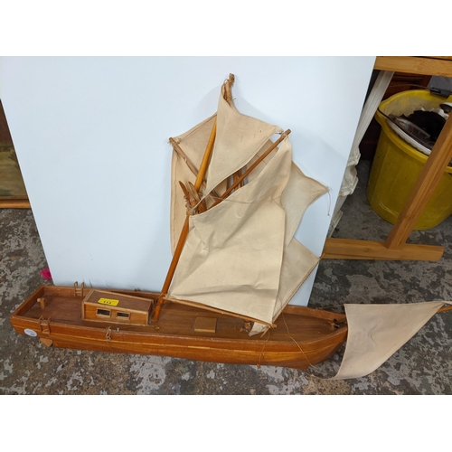 113 - Two wooden models of sailing boats to include a painted example raised on a stand
Location: G