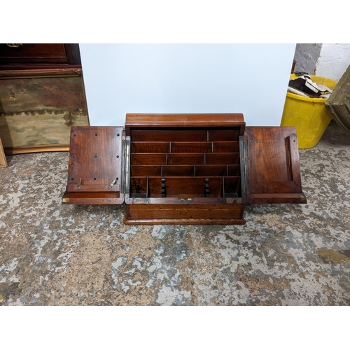 115 - A Victorian oak desk stand having two doors opening to reveal a fitted interior, together with Whiel... 