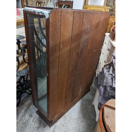 124 - An Art Deco two door glazed display cabinet with glass shelves and on a plinth base, 136.5H x 107w
L... 