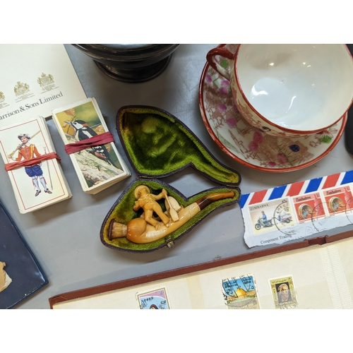 323 - A mixed lot of collectables to include a carved smoking pipe, stamps, silver plated platter and othe... 