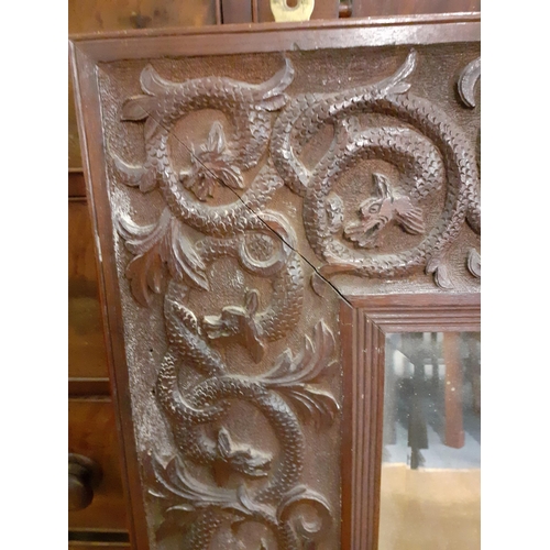 384 - A 20th century Chinese carved hardwood wall mirror with images of intertwining sea serpents, 88cm h ... 