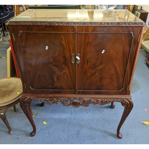 43 - A late 20th century mahogany drinks cocktail cabinet with carved ornament and twin doors, on cabriol... 