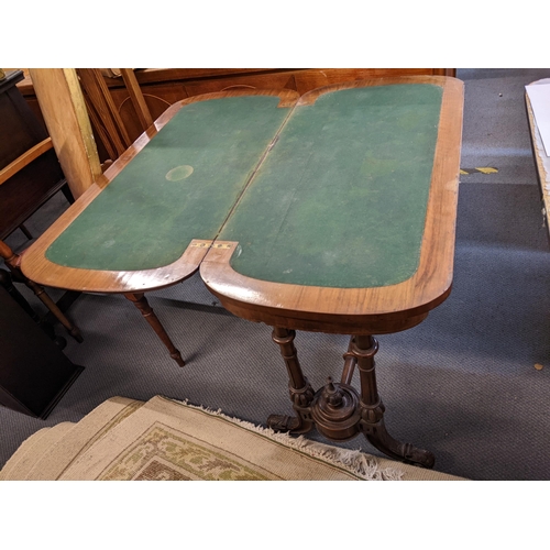 353 - A Victorian walnut fold over card table having turned supports, green baize and scroll shaped feet, ... 