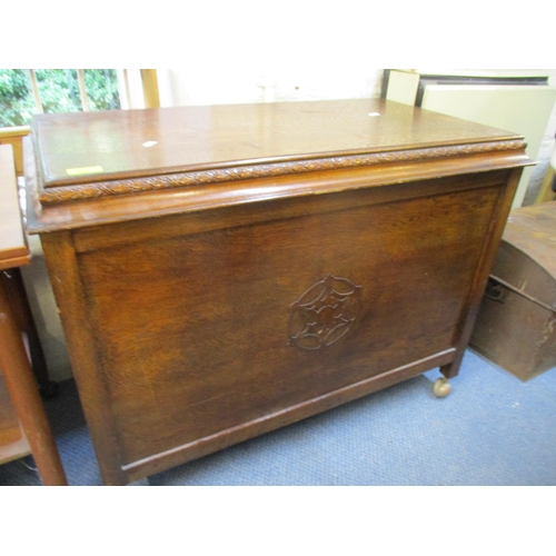 307 - A carved oak linen chest with hinged top on castors, and a mid-century teak foldover tea table with ... 