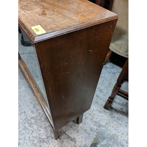 489 - An early/mid 20th century oak cabinet having two glazed sliding doors and on block shaped legs, 94cm... 