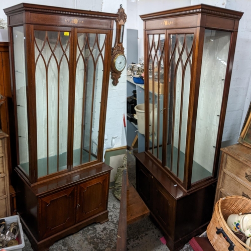 493 - A pair of reproduction mahogany display cabinets having dental moulded cornice, glazed doors, two cu... 