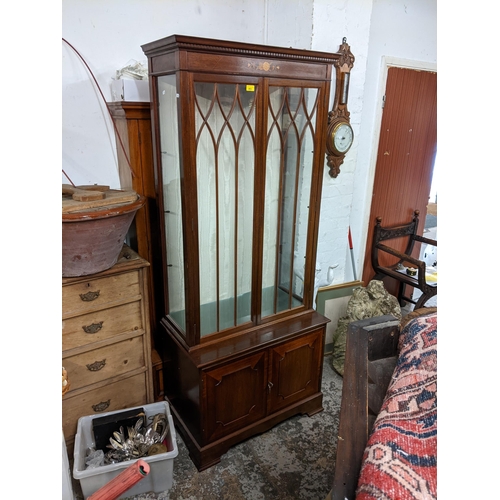 493 - A pair of reproduction mahogany display cabinets having dental moulded cornice, glazed doors, two cu... 