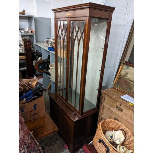 493 - A pair of reproduction mahogany display cabinets having dental moulded cornice, glazed doors, two cu... 