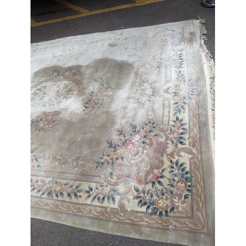 500 - A Chinese machine woven cream ground carpet having a floral design with a central motif, 370cm x 276... 