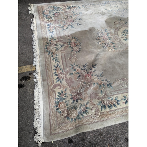 500 - A Chinese machine woven cream ground carpet having a floral design with a central motif, 370cm x 276... 