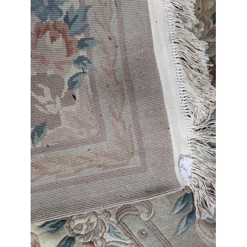 500 - A Chinese machine woven cream ground carpet having a floral design with a central motif, 370cm x 276... 