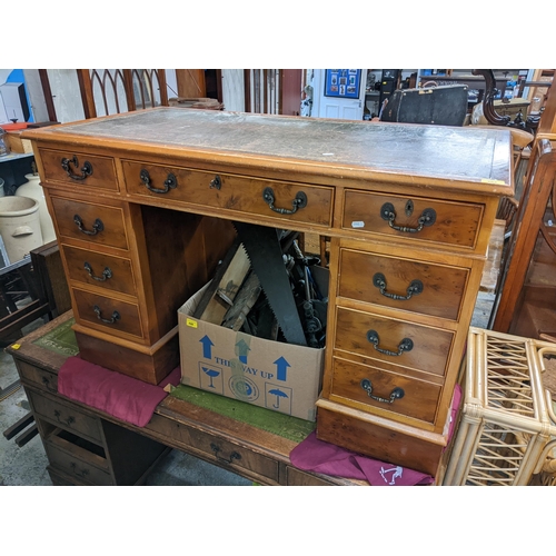 494 - A reproduction yew twin pedestal desk having a leather topped scriber and nine drawers, 77cm h x 122... 